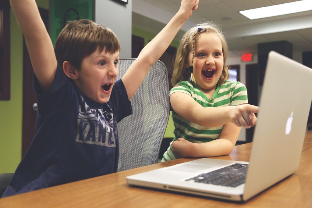 Kids enjoying playing playing games in a computer