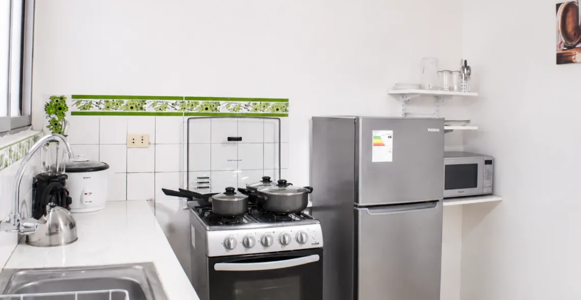 Cocina completamente equipada con electrodomésticos en departamento amoblado